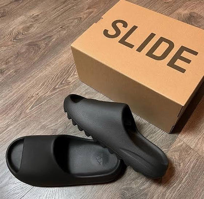 lifestyle indoor picture of the yeezy slide onyx with box