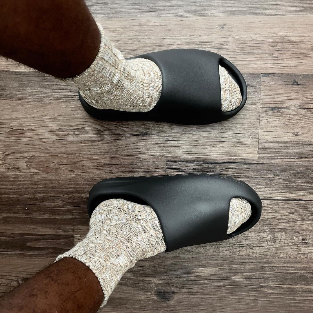 picture of the yeezy slide onyx on feet indoors