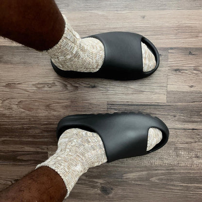 picture of the yeezy slide onyx on feet indoors